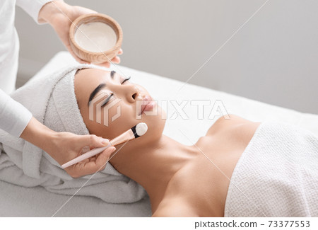 Attractive young asian woman receiving skin treatment at spa center Attractive young asian woman receiving skin treatment at spa center 73377553