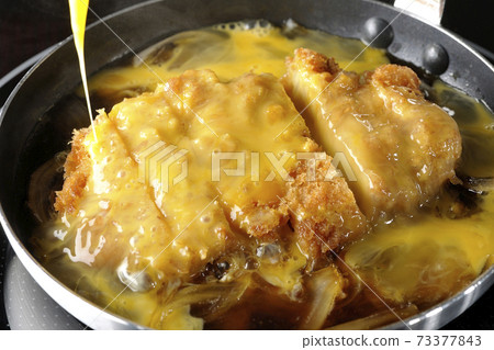 Cooking scene where cutlets and onions are boiled in a parent-child pot compatible with an IH cooking heater and bound with eggs Cooking scene where cutlets and onions are boiled in a parent-child pot compatible with an IH cooking heater and bound with eggs 73377843