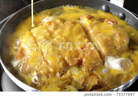 Cooking scene where cutlets and onions are boiled in a parent-child pot compatible with an IH cooking heater and bound with eggs Cooking scene where cutlets and onions are boiled in a parent-child pot compatible with an IH cooking heater and bound with eggs 73377847