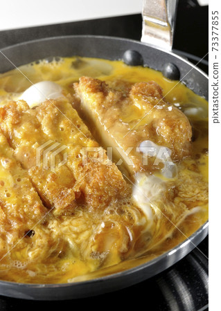 Cooking scene where cutlets and onions are boiled in a parent-child pot compatible with an IH cooking heater and bound with eggs Cooking scene where cutlets and onions are boiled in a parent-child pot compatible with an IH cooking heater and bound with eggs 73377855