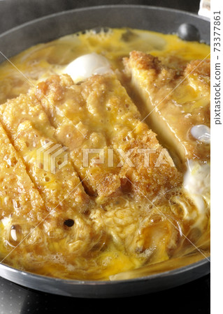 Cooking scene where cutlets and onions are boiled in a parent-child pot compatible with an IH cooking heater and bound with eggs Cooking scene where cutlets and onions are boiled in a parent-child pot compatible with an IH cooking heater and bound with eggs 73377861