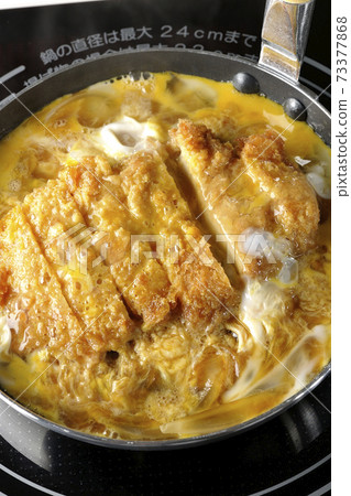 Cooking scene where cutlets and onions are boiled in a parent-child pot compatible with an IH cooking heater and bound with eggs Cooking scene where cutlets and onions are boiled in a parent-child pot compatible with an IH cooking heater and bound with eggs 73377868