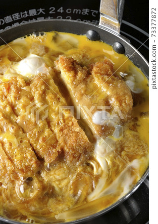 Cooking scene where cutlets and onions are boiled in a parent-child pot compatible with an IH cooking heater and bound with eggs Cooking scene where cutlets and onions are boiled in a parent-child pot compatible with an IH cooking heater and bound with eggs 73377872