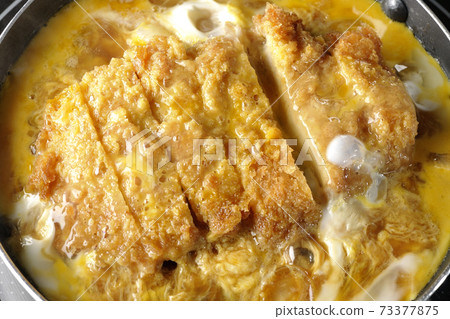 Cooking scene where cutlets and onions are boiled in a parent-child pot compatible with an IH cooking heater and bound with eggs Cooking scene where cutlets and onions are boiled in a parent-child pot compatible with an IH cooking heater and bound with eggs 73377875