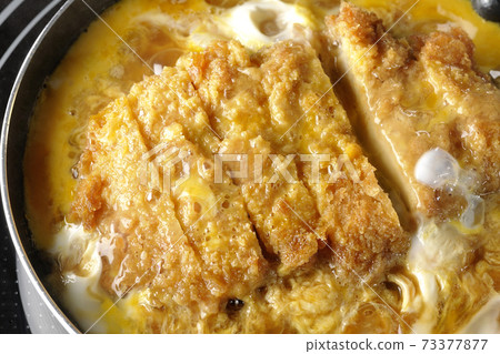 Cooking scene where cutlets and onions are boiled in a parent-child pot compatible with an IH cooking heater and bound with eggs Cooking scene where cutlets and onions are boiled in a parent-child pot compatible with an IH cooking heater and bound with eggs 73377877