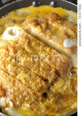 Cooking scene where cutlets and onions are boiled in a parent-child pot compatible with an IH cooking heater and bound with eggs Cooking scene where cutlets and onions are boiled in a parent-child pot compatible with an IH cooking heater and bound with eggs 73377882
