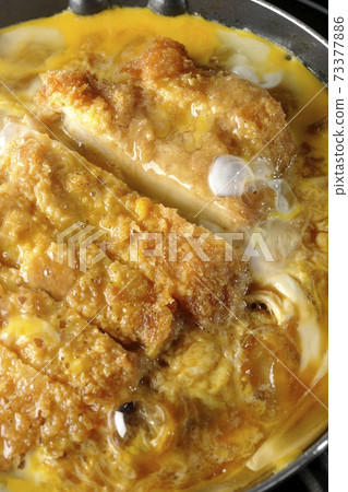 Cooking scene where cutlets and onions are boiled in a parent-child pot compatible with an IH cooking heater and bound with eggs Cooking scene where cutlets and onions are boiled in a parent-child pot compatible with an IH cooking heater and bound with eggs 73377886