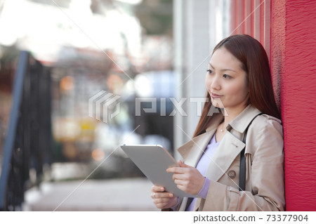 平板電腦在城市中的一名女子 73377904