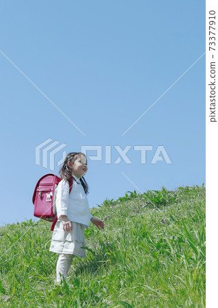 Girls carrying a school bag 73377910