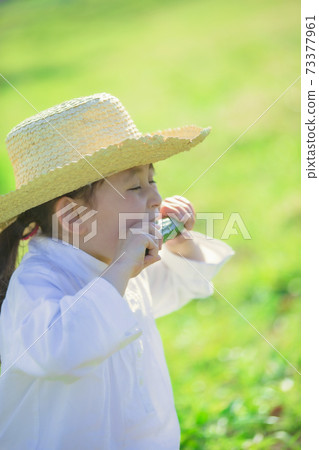 Girl chewing cucumber 73377961