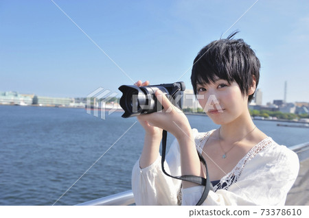 A woman shooting with a digital camera A woman shooting with a digital camera 73378610