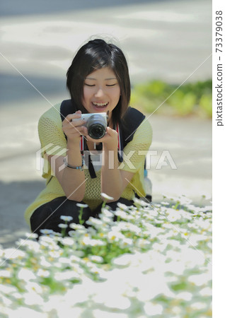 A woman holding a camera 73379038