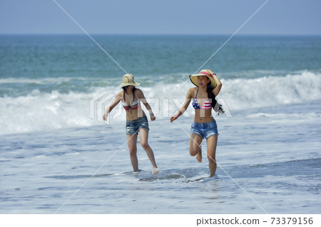 跑在海灘的兩名泳裝婦女 跑在海灘的兩名泳裝婦女 73379156