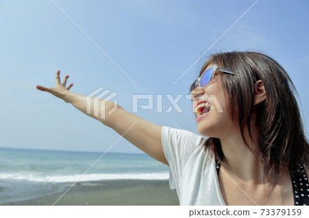 A seaside woman wearing sunglasses A seaside woman wearing sunglasses 73379159