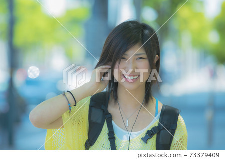 Women listening to music with earphones Women listening to music with earphones 73379409