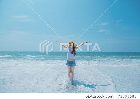 A woman standing at the beach A woman standing at the beach 73379593