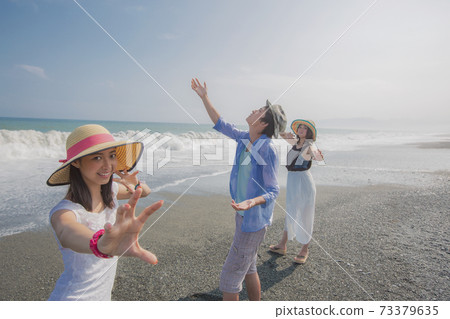 擺在海灘的三青年人 73379635