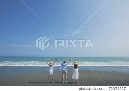 Three young people posing at the beach behind the scenes Three young people posing at the beach behind the scenes 73379637