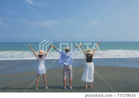 Three young people posing at the beach behind the scenes Three young people posing at the beach behind the scenes 73379638