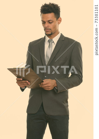 Young African businessman reading on clipboard 73381101