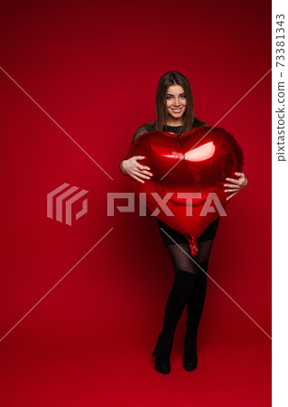 Heart shaped balloon in girl's arms. Saint 73381343
