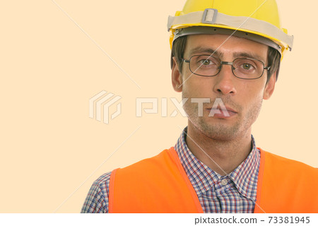 Close up of young handsome man construction worker wearing eyeglasses 73381945