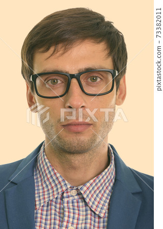Face of young handsome businessman wearing eyeglasses Face of young handsome businessman wearing eyeglasses 73382011