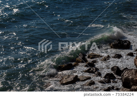Ocean wave background breaking sea water rocky shore 73384224