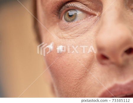 Close up of female face with eye cream Close up of female face with eye cream 73385112