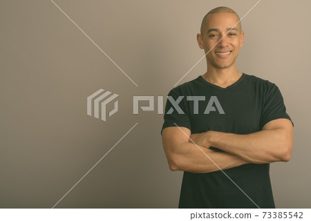 Handsome bald man wearing black shirt against gray background 73385542