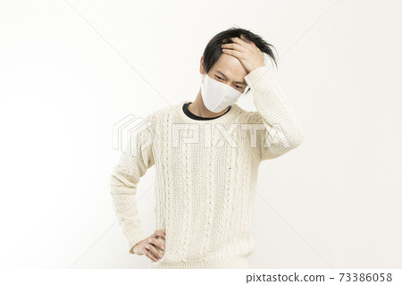 A man in a mask / holding his head with a headache / a single man who is sick / A man in a mask / holding his head with a headache / a single man who is sick / 73386058