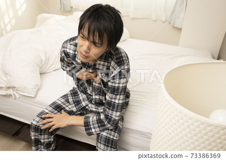 一個穿著睡衣的男人，因為早上的飲酒會一直持續到深夜，所以早上早上胸口不會灼痛 73386369