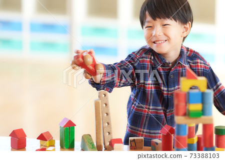 Little boy playing with blocks 73388103