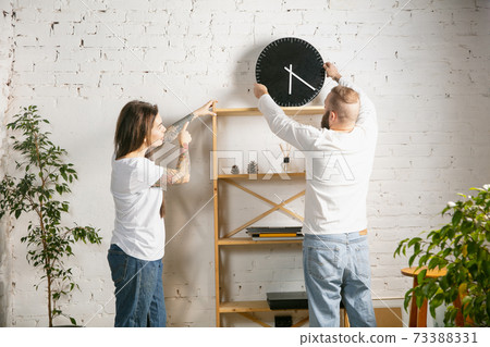 Young family doing apartment repair together themselves. Married man and woman doing home makeover or renovation Young family doing apartment repair together themselves. Married man and woman doing home makeover or renovation 73388331