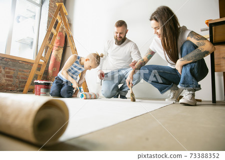 Young family doing apartment repair together themselves. Mother, father and son doing home makeover or renovation 73388352
