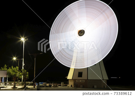 Windmill wings rotating at night 73389612