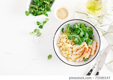 Grilled chicken breast, pasta and fresh lamb salad in lunch bowl. Top view Grilled chicken breast, pasta and fresh lamb salad in lunch bowl. Top view 73390147