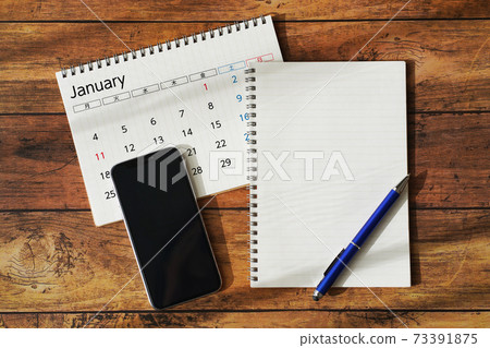 Calendar, schedule and smartphone placed on a wood grain desk 73391875
