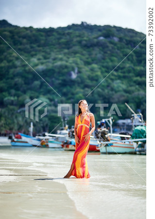 Sexy girl i long dress posing on the tropical beach 73392002