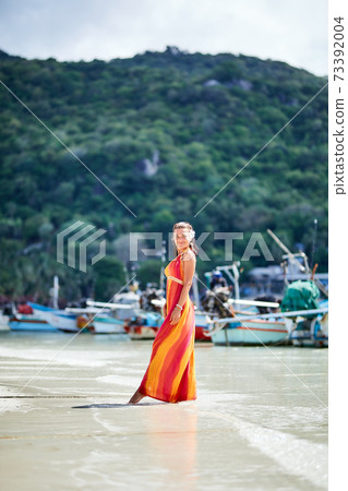 Sexy girl i long dress posing on the tropical beach 73392004