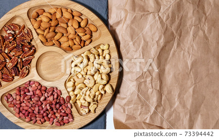 Cashews, pecans, peanuts, almonds. Various nuts on the stone table. Top view with space to copy. 73394442