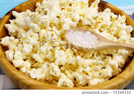 Popcorn in bowl on a blue background. selective focus. close-up. Copy, empty space for text 73394510