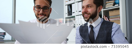 Smiling men at computer holding in arms financial papers Smiling men at computer holding in arms financial papers 73395045