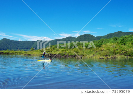 男人和狗在夏天享受站立式槳在湖上沖浪 男人和狗在夏天享受站立式槳在湖上沖浪 73395079