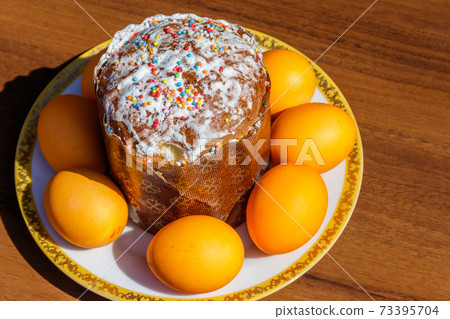 Easter cake and painted eggs on a table 73395704