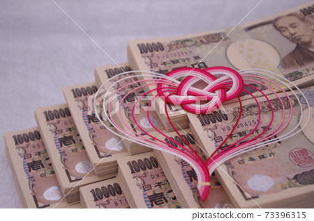 A wad of bills piled up in a staircase and a cute Mizuhiki heart 73396315