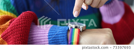 Woman in an lgbt sweater points her finger at clock face. Woman in an lgbt sweater points her finger at clock face. 73397693