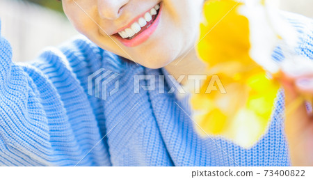 Young woman with ginkgo leaves Young woman with ginkgo leaves 73400822