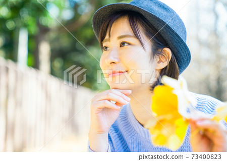 Young woman with ginkgo leaves 73400823