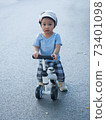 Cute baby asian boy learning to ride his first running bike 73401098